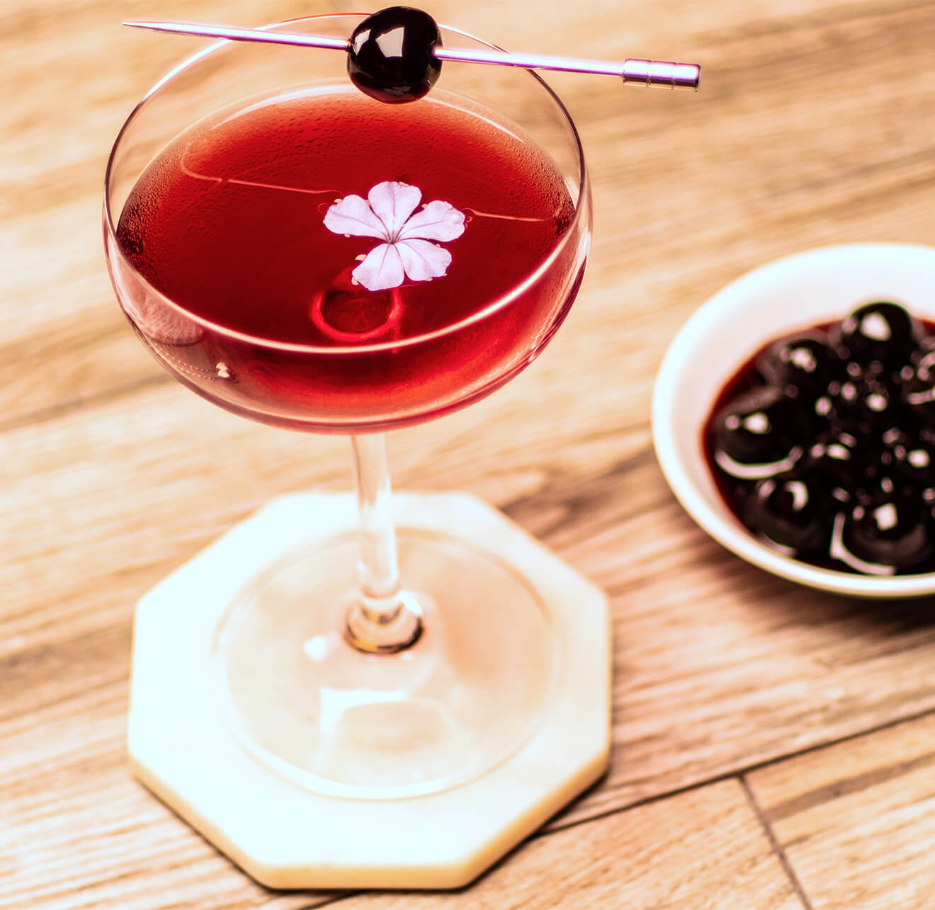 american pie manhattan cocktail with flower garnish