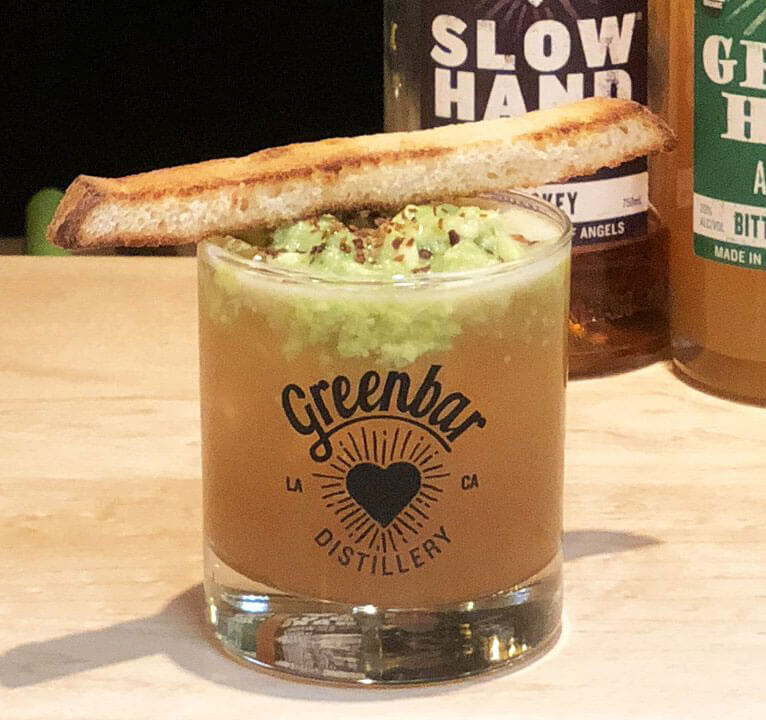 Avocado Smash, cocktail with toast garnish and bottles