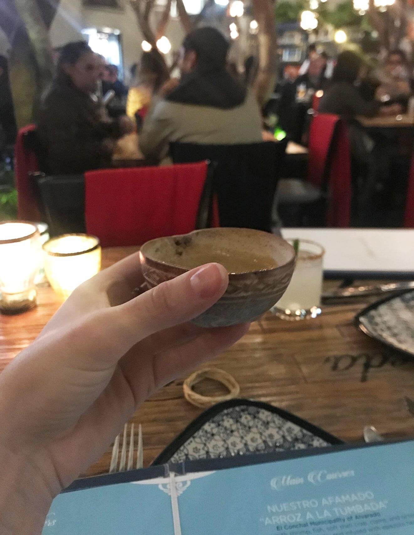 Azul holding a cocktail in bar