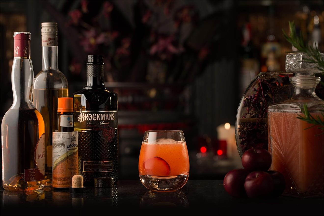 Brockmans Plum Delicious, cocktail with bottle, garnish background cocktail with garn