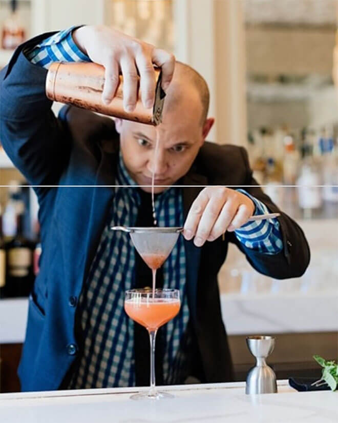 Bartender Steven Huddleston mixing a cocktail behind the bar