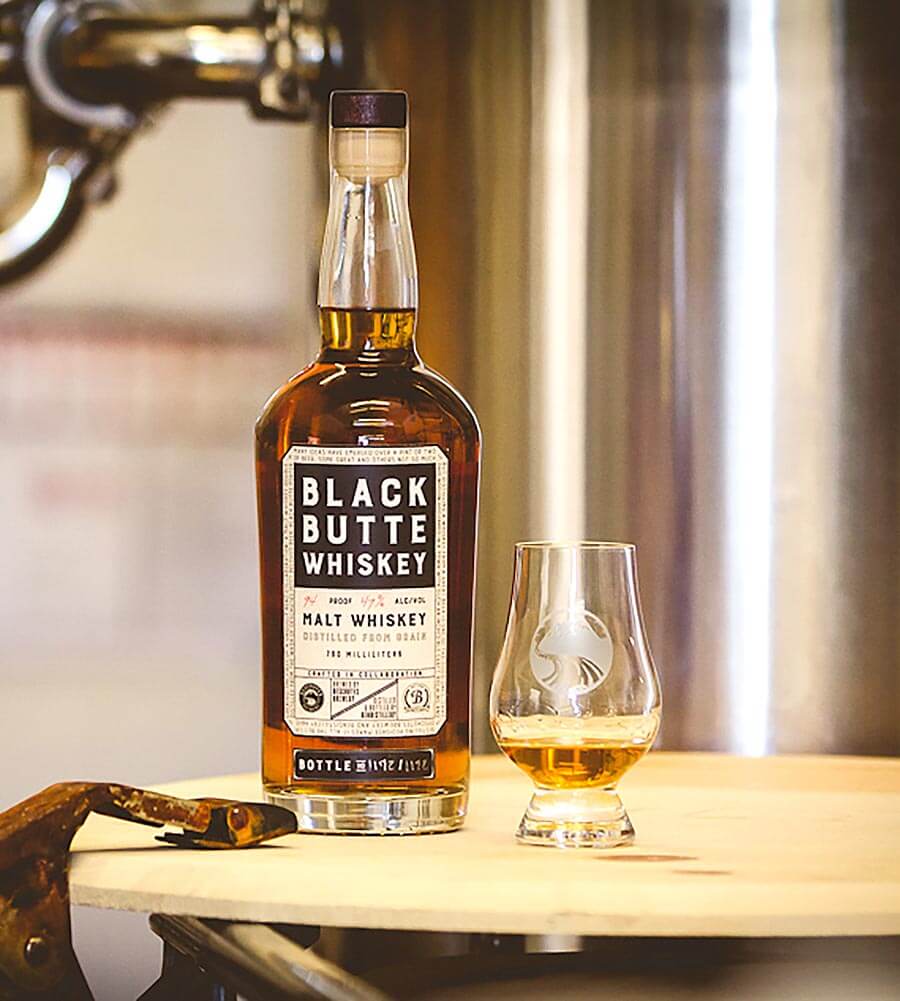 Black Butte Whiskey, bottle and glass, distillery background