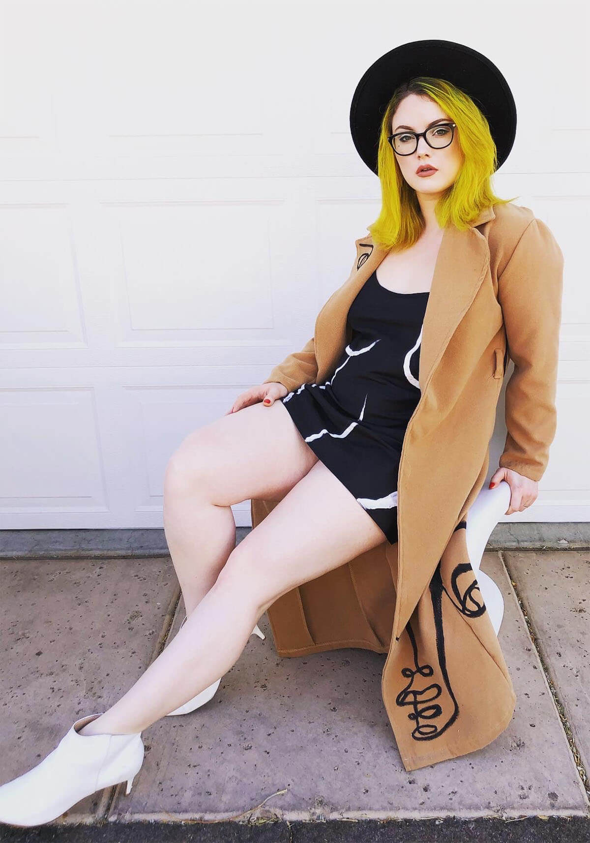 Briana Lark, portrait, long tan jacket, black hat