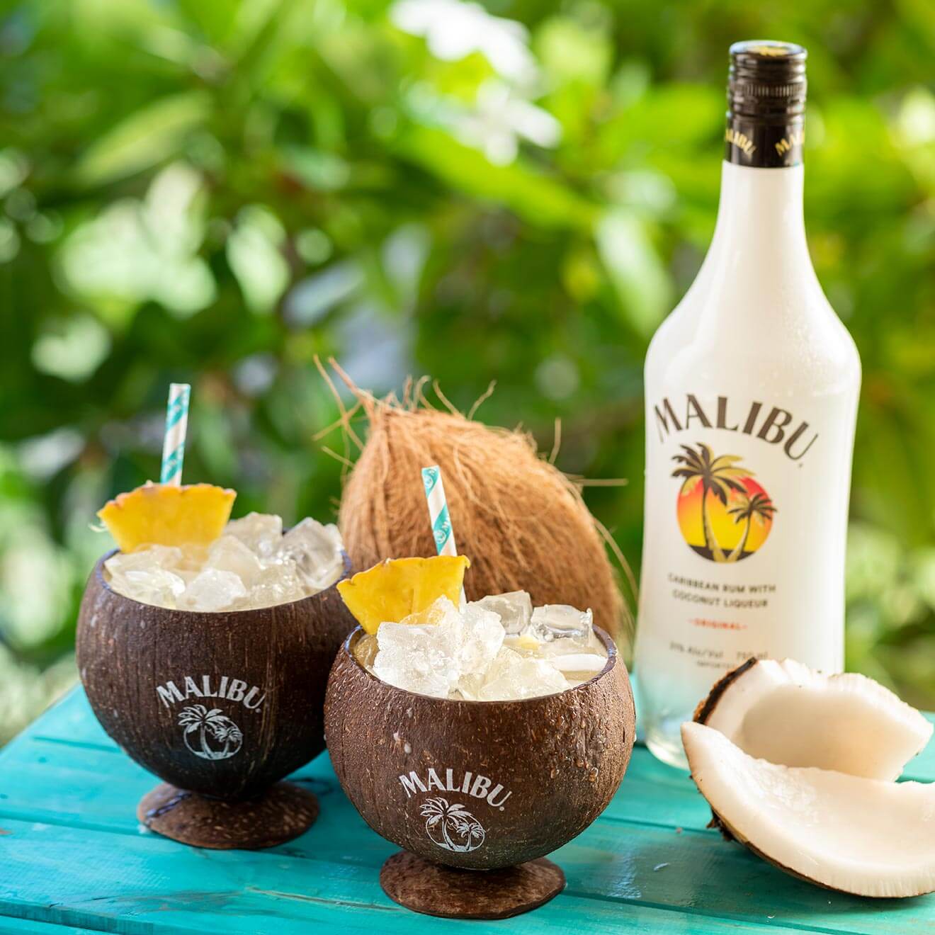 bubbly Piña Colada cocktails in coconuts with bottle