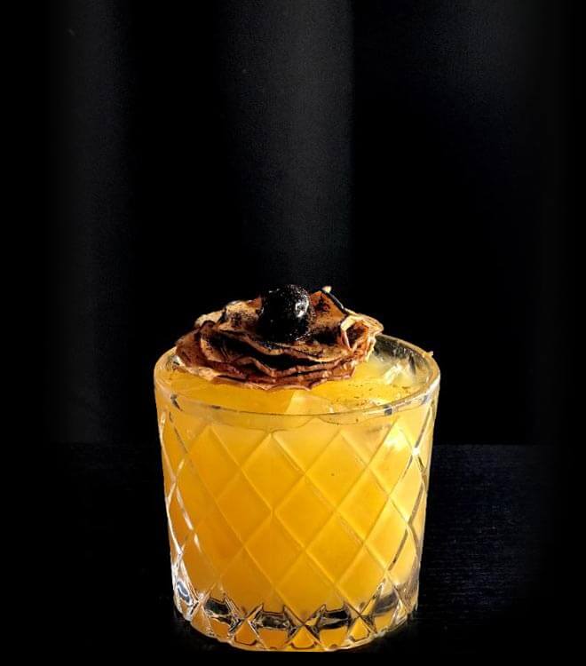 Cobra Fang cocktail with garnish, dark background