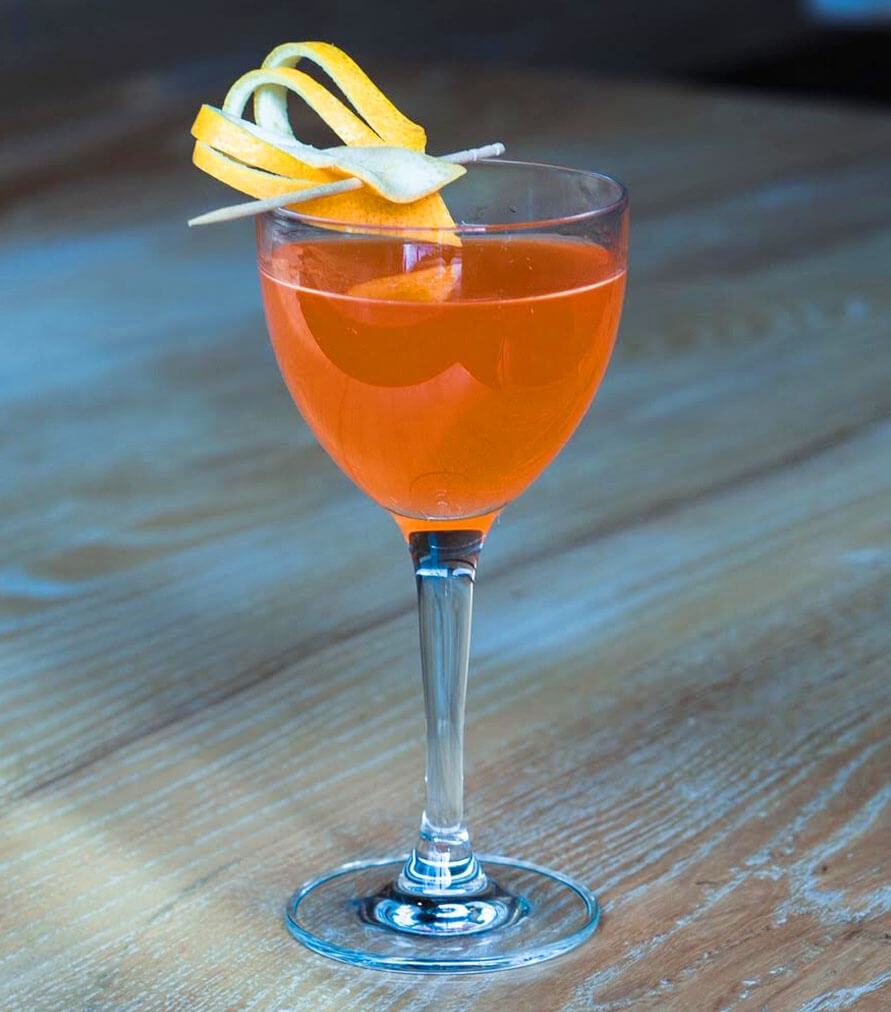 Cocktail at Alibi, wine glass, chalice, lemon rind garnish