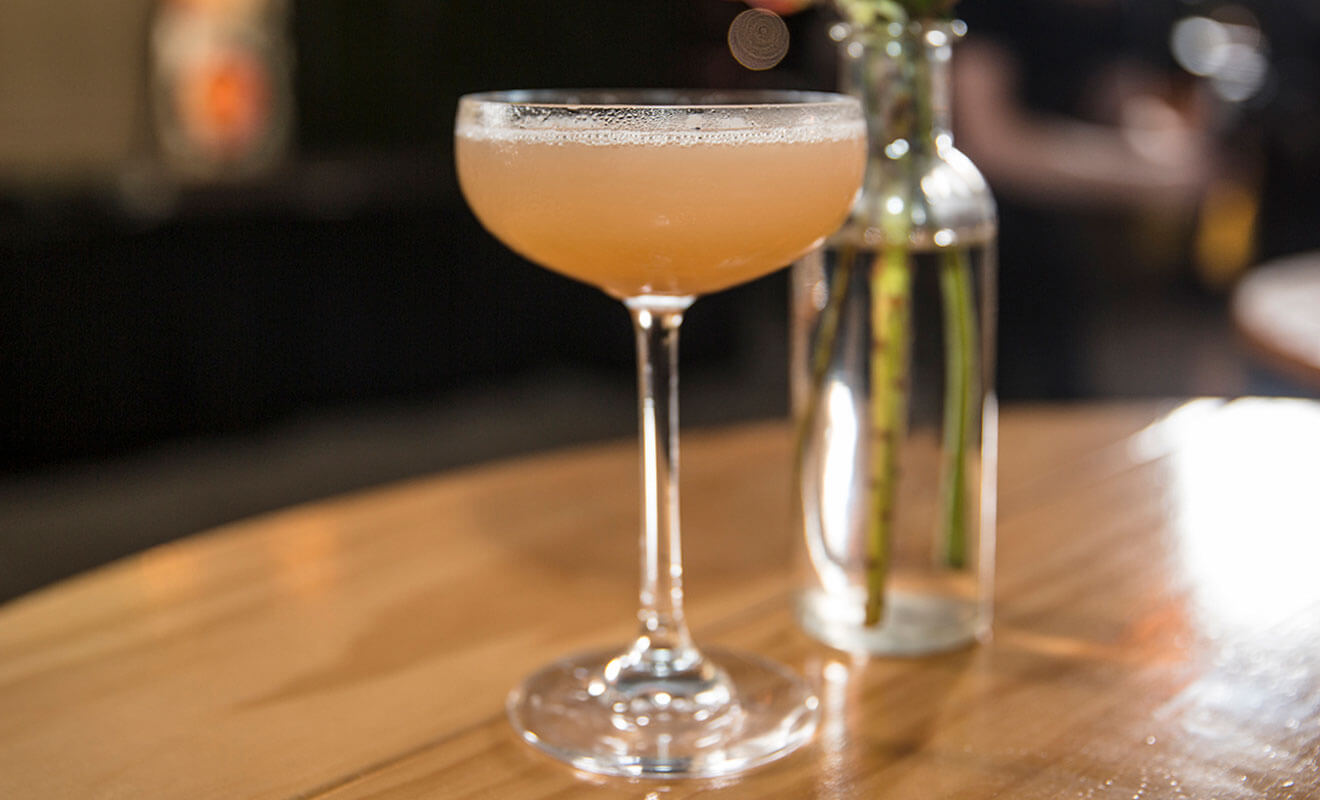 Coki Beach cocktail image with bottle on table
