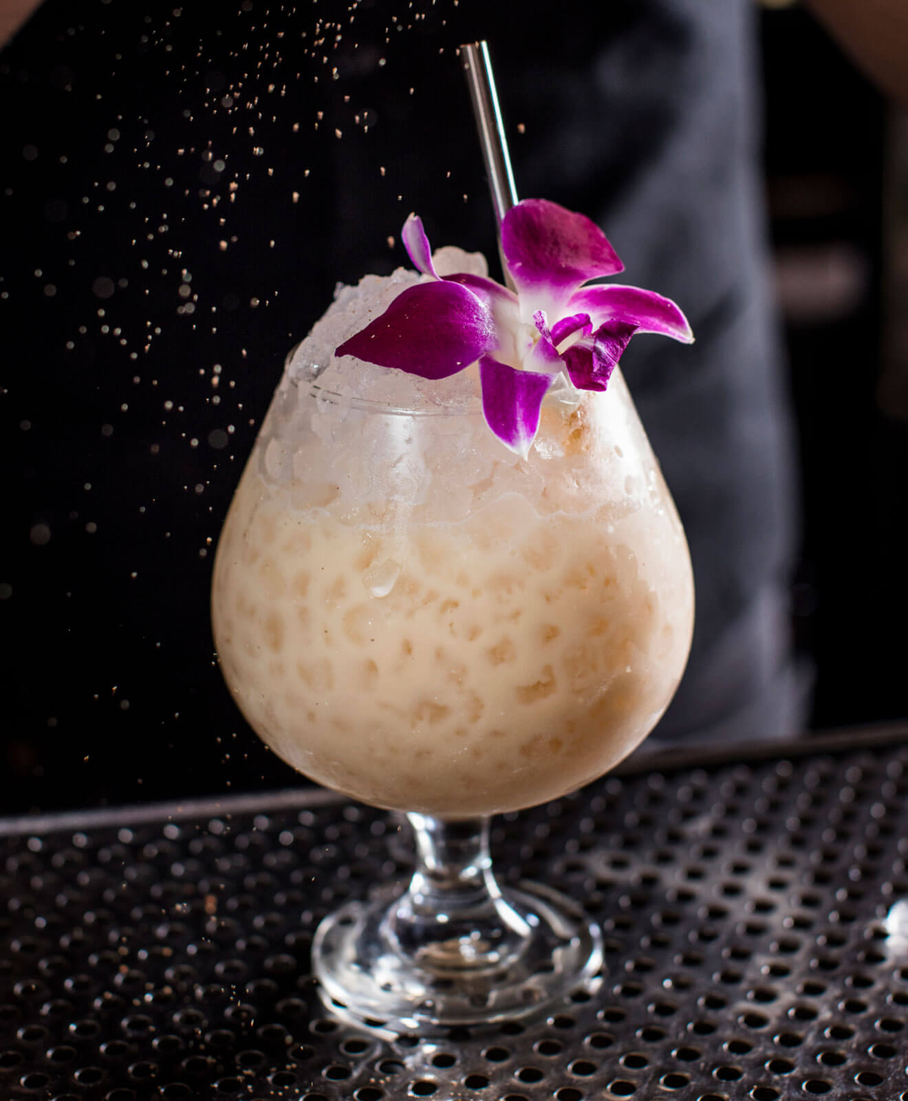 Death & Co Cocktail with edible flower garnish