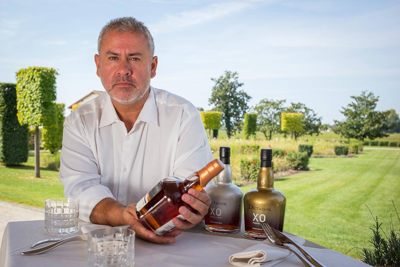 Dictador Rum Master Blender Hernan Parra, holding bottles