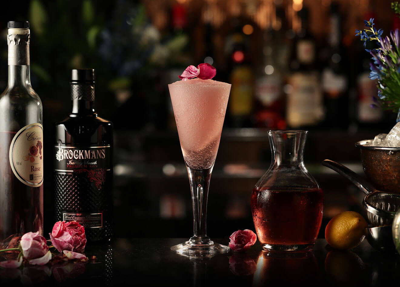 Frosé, cocktail with garnishes, bottles, dark background