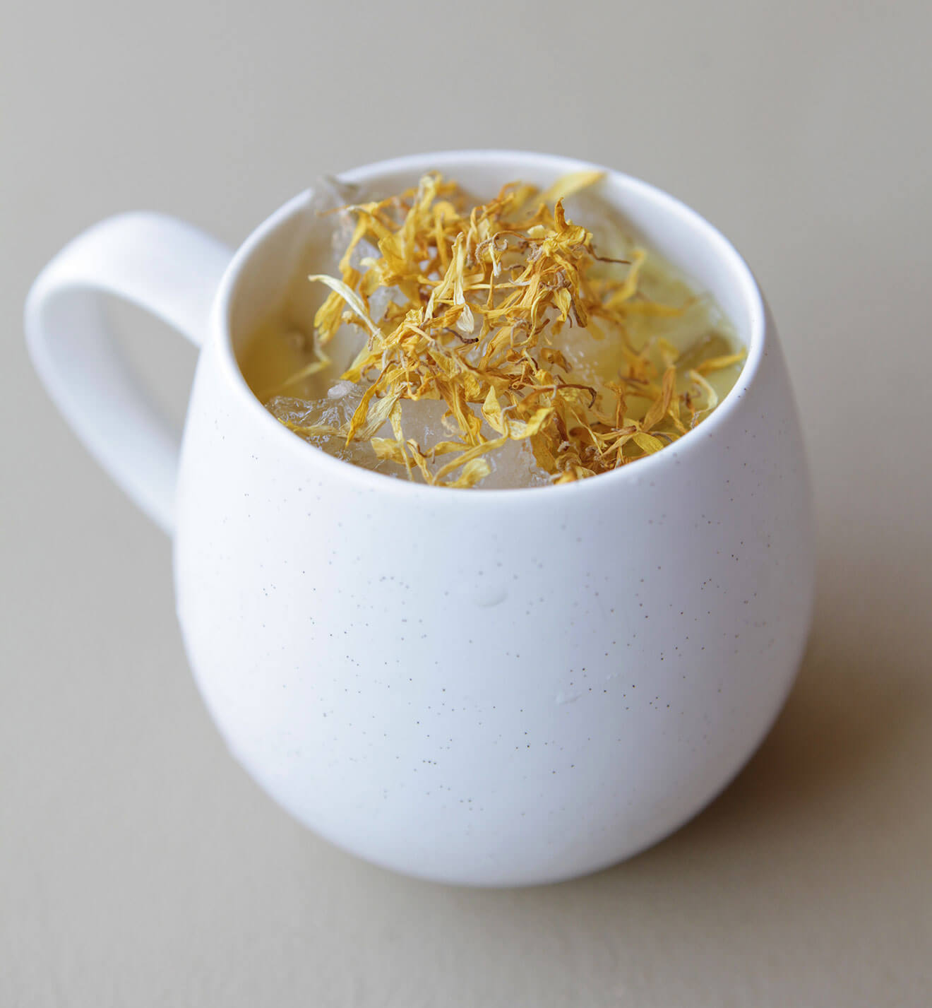 Golden Year cocktail with dried flower garnish