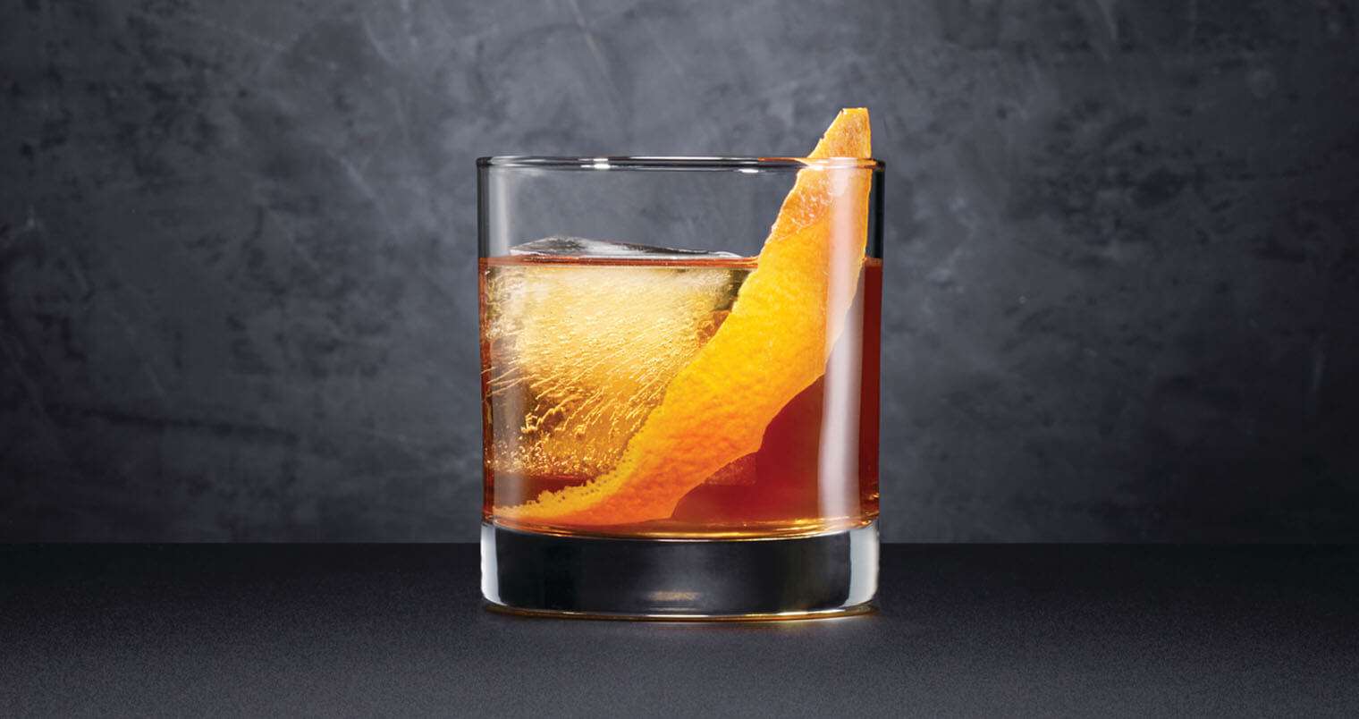 Black Barrel Old Fashioned, cocktail with garnish, dark grey background, featured image