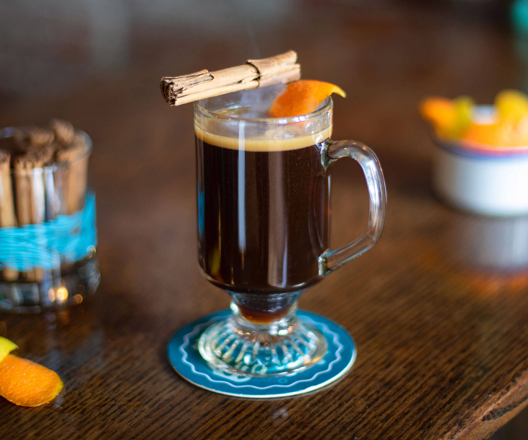 Kona Coffee Grog, cocktail on coaster with multiple garsnishes