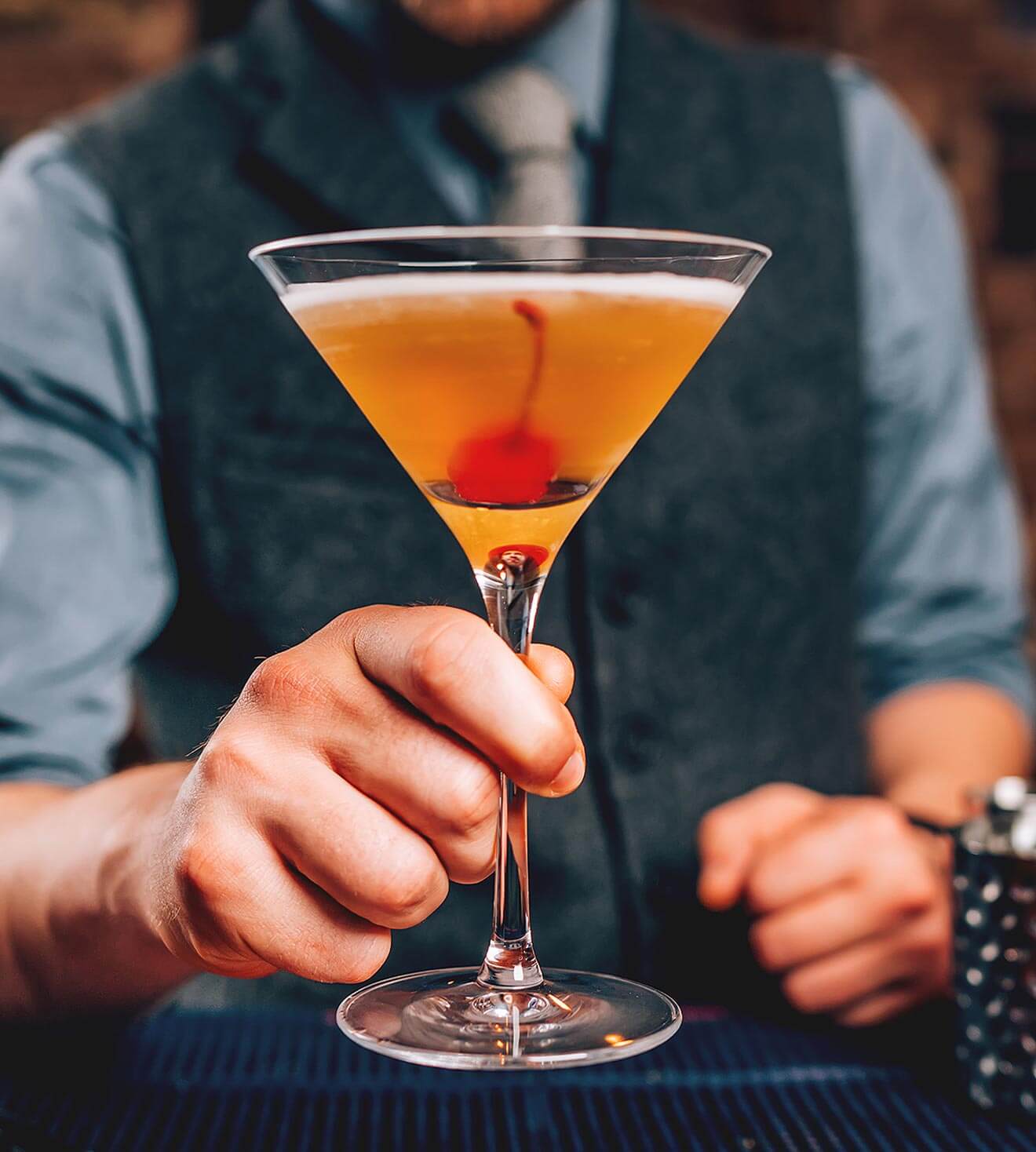 Manhattan Month 2018, bartender holding manhattan cocktail