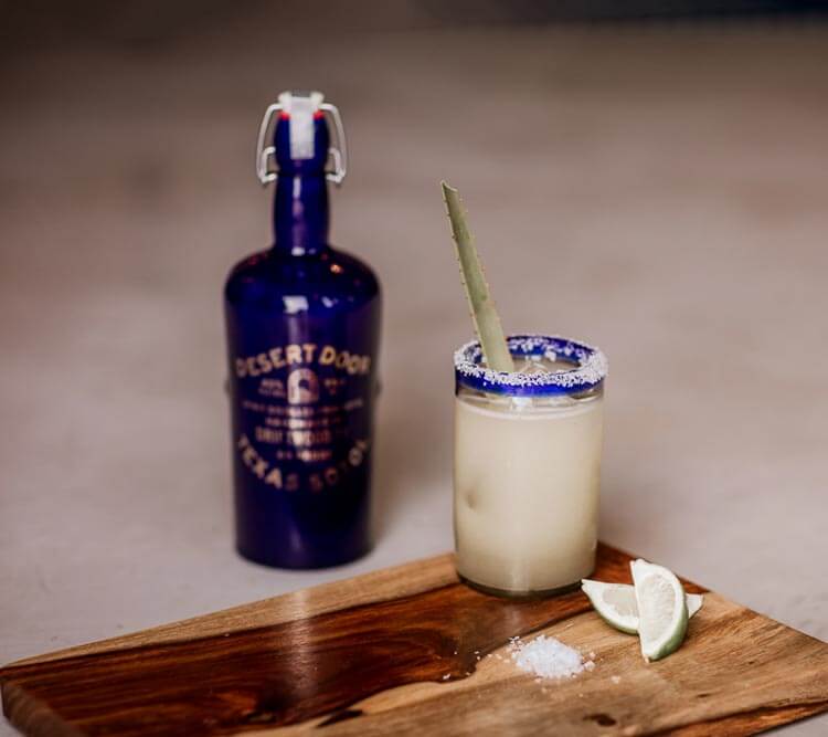 Marfarita bottle and cocktail with garnish, wooden board