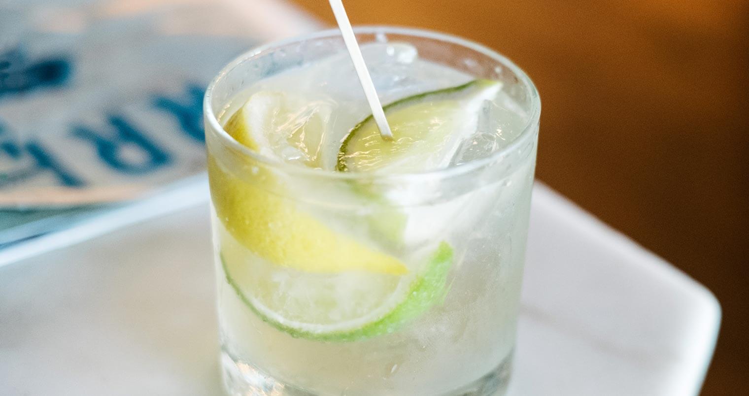 Mexican Bucha cocktail with lime wedges, featured image