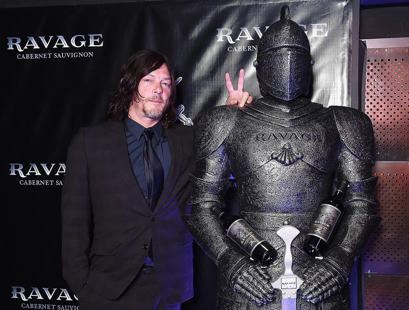 Norman Reedus gets friendly with a Ravage-Wines knight on the black carpet at Comic-Con's Heroes After Dark party