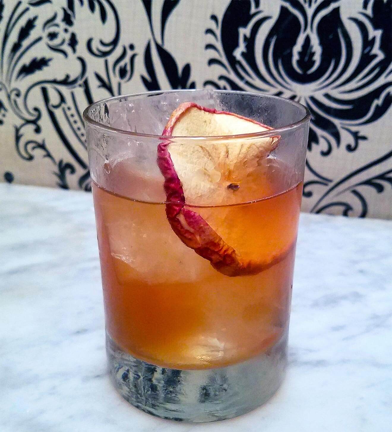 Orchard Negroni on marble top, ornate background