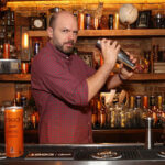 Paul Scheer mixing behind the bar