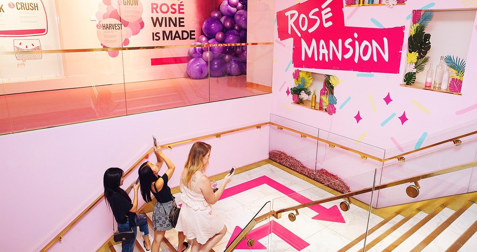 Rosé All Day at Rosé Mansion, girls ascending staircase, snapping photos, featured image