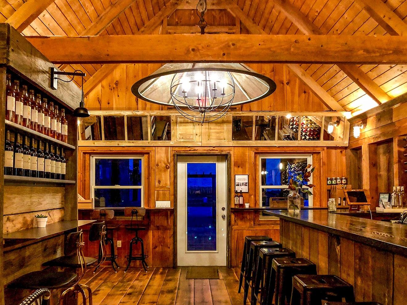 Shinn Estate Tasting Patio, room with wood paneling, bottles on shelves