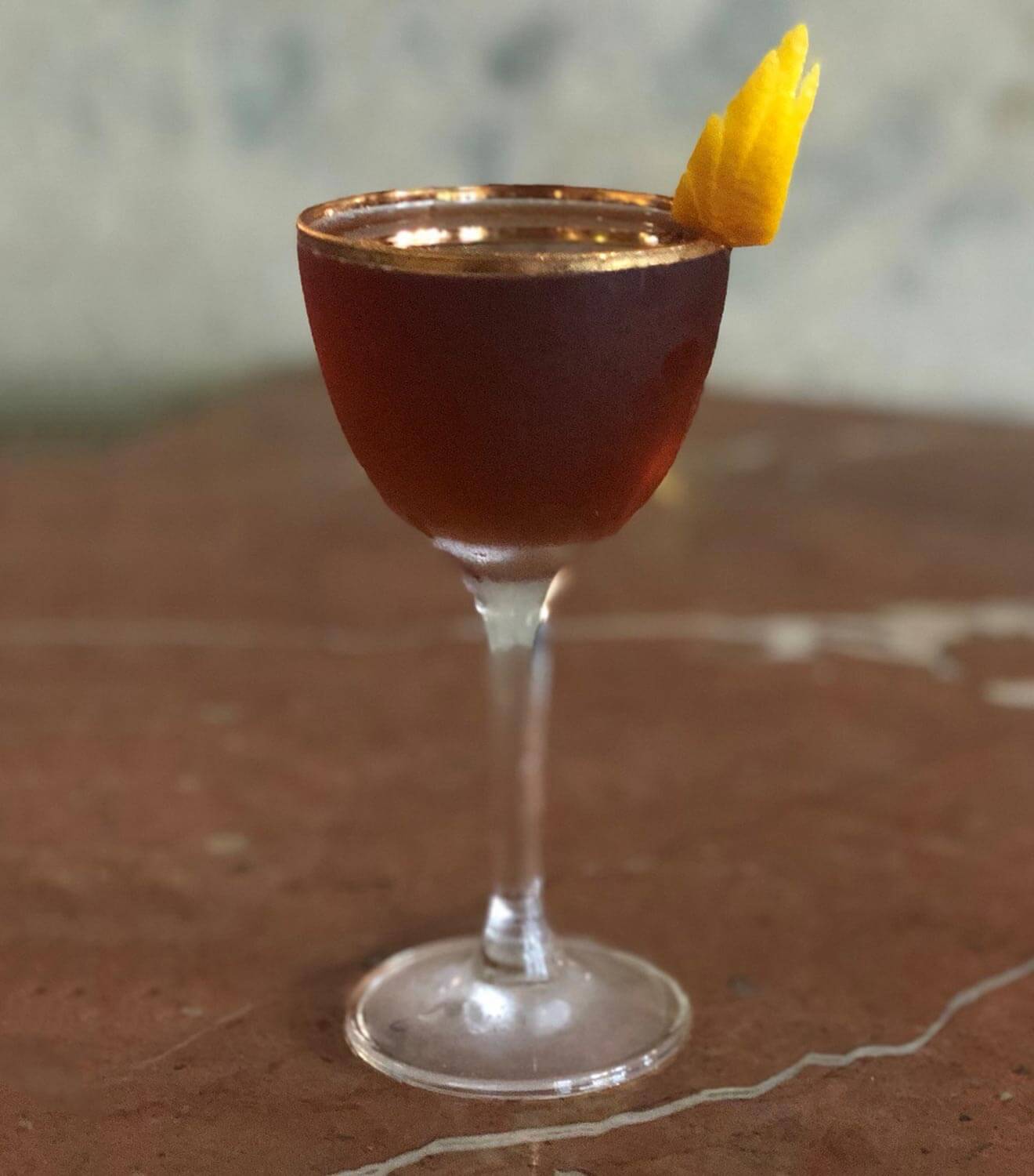 Sloe Ryder cocktail with lemon wing garnish