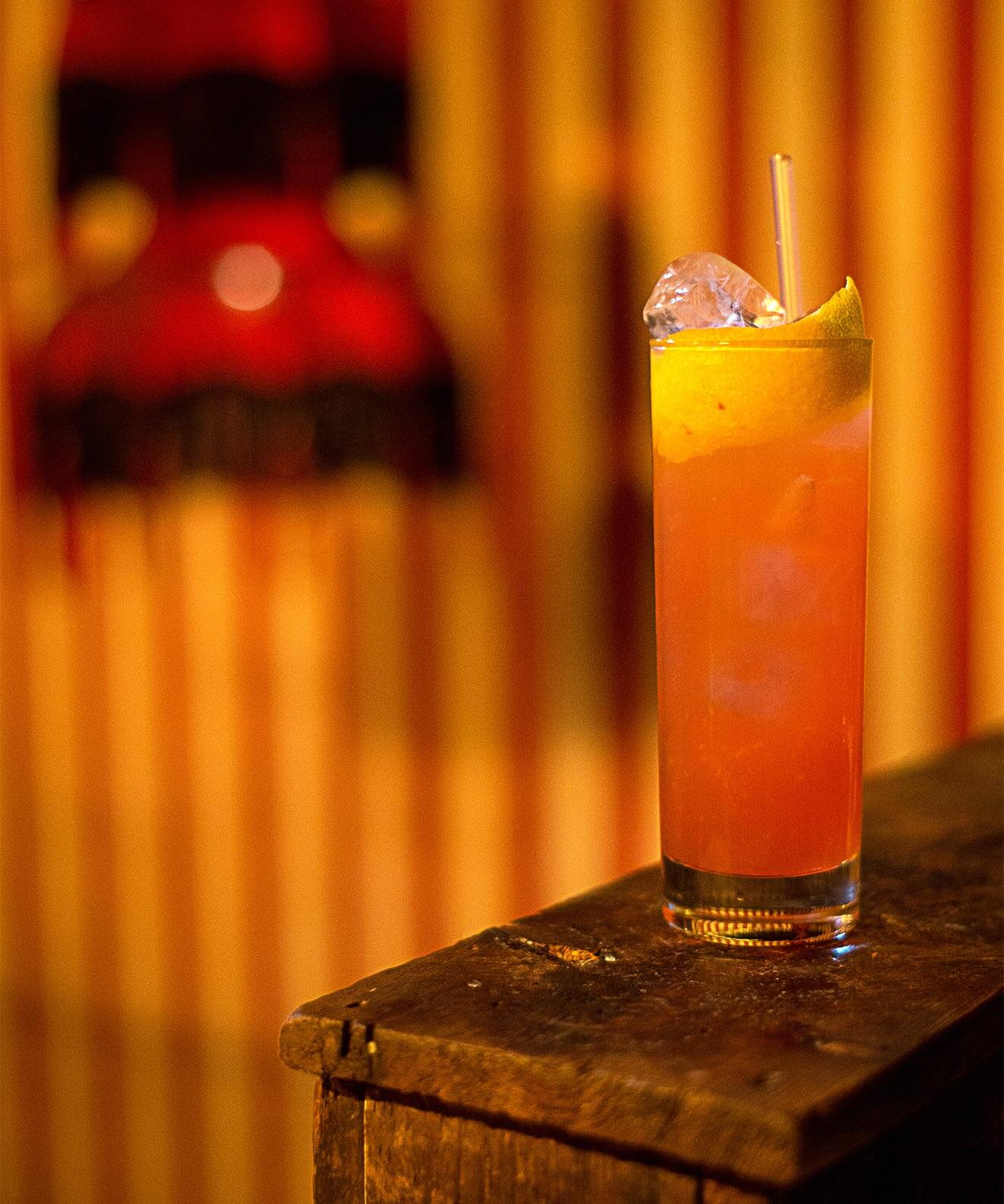 St. Kevin Sling cocktail with warm striped background