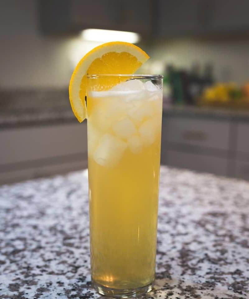 Super Bowl Shandy cocktail with lemon garnish, marble table