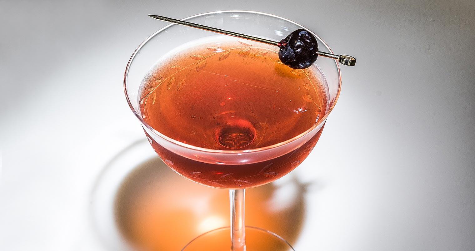 Surfer Rob Roy cocktail with toothipick garnish, featured image