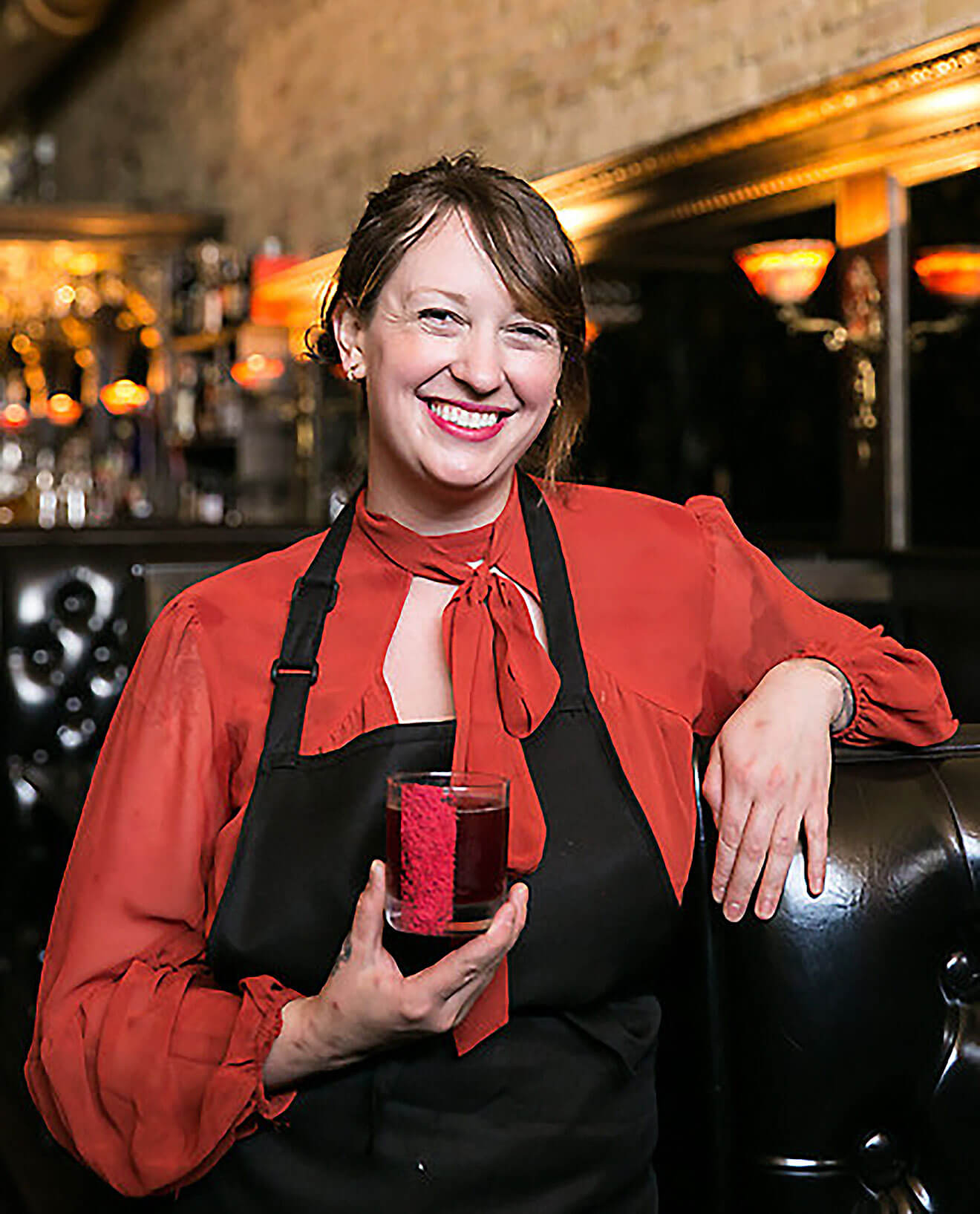 Tacy Rowland, side of the bar, presenting cocktail