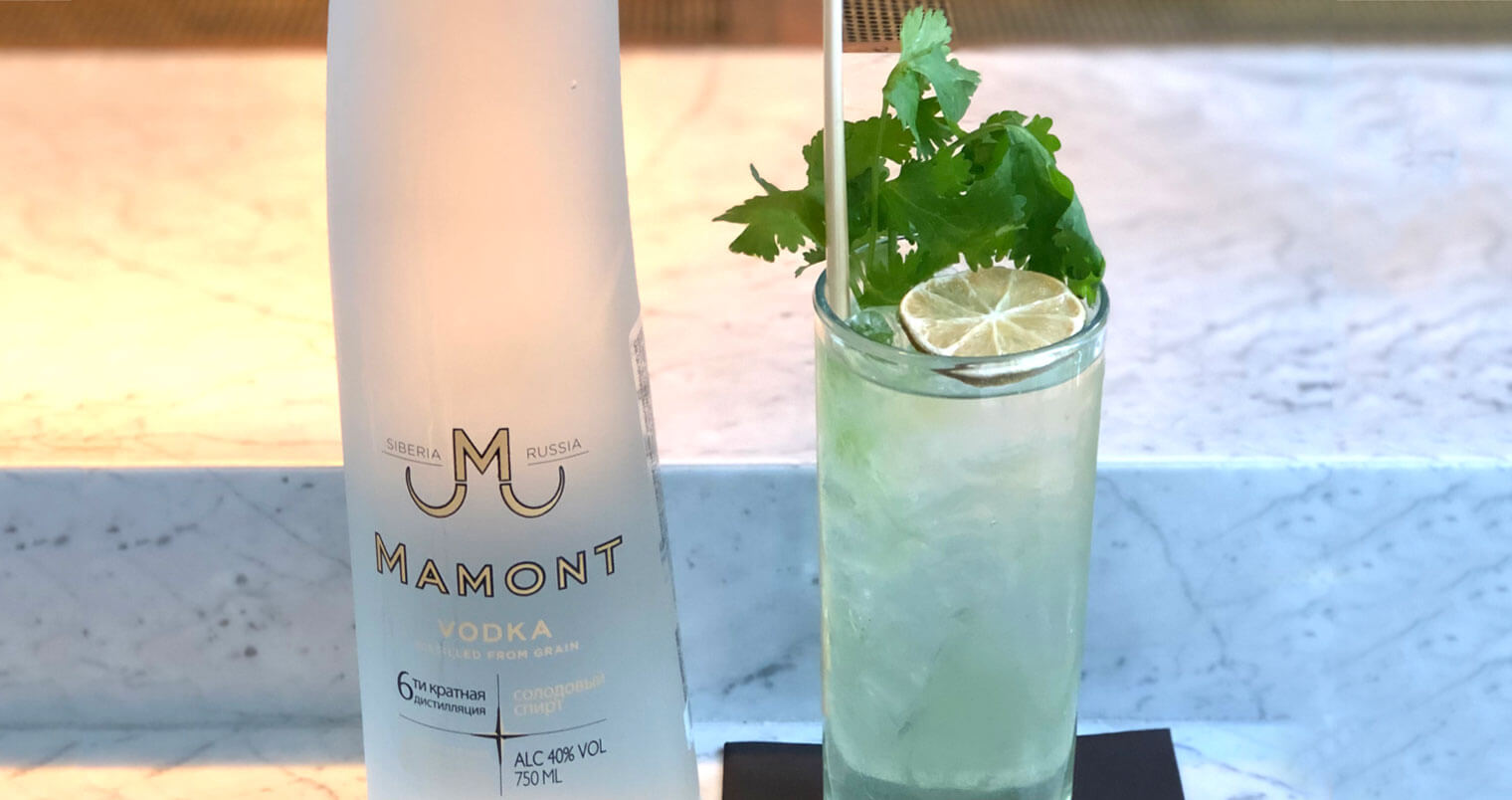 The Jolly Green Mamont, bottle and cocktail, marble table, cocktail napkin, featured image