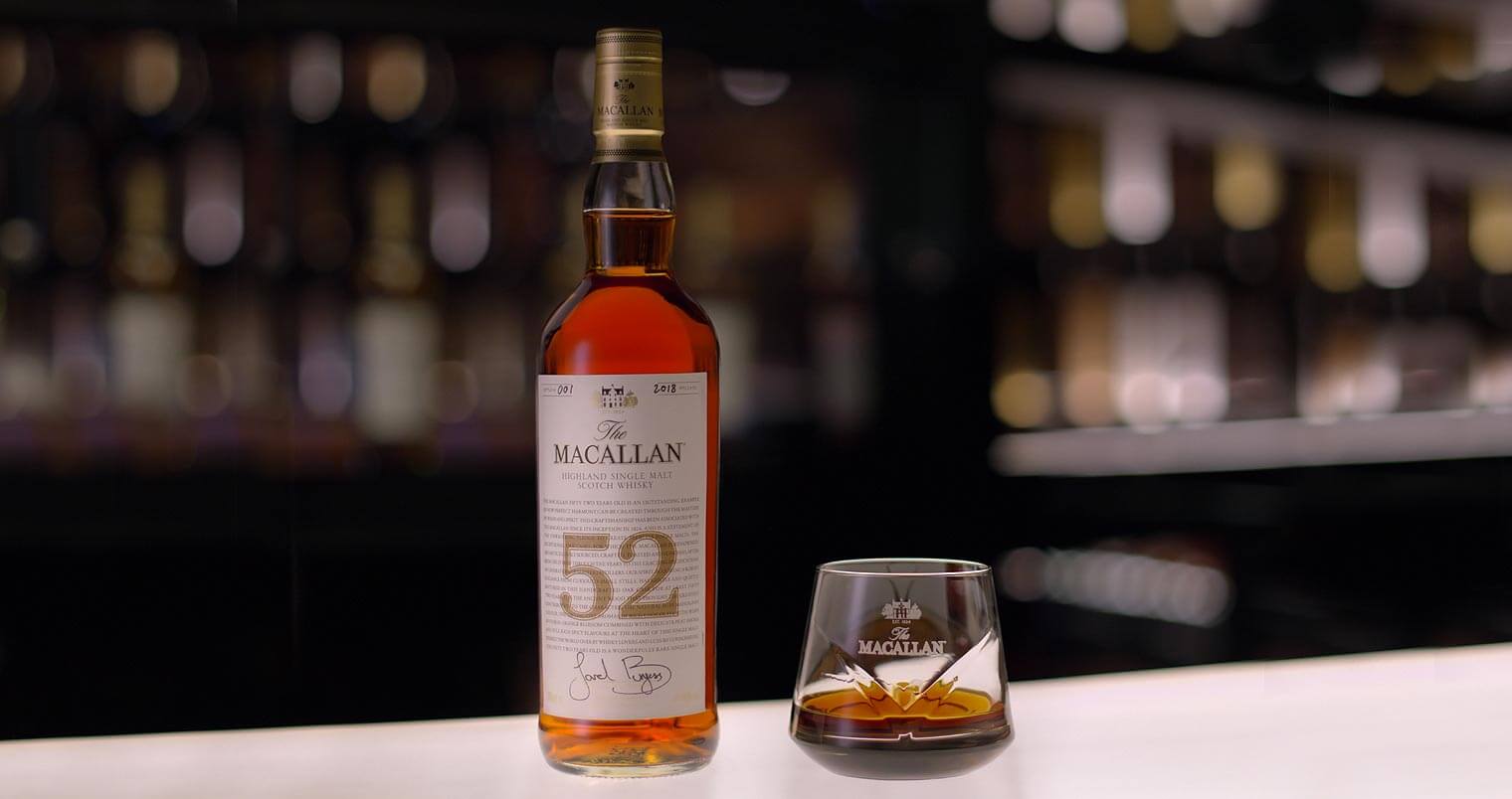 The Macallan 52 years old 2018, bottle and glass on bar table, featured image