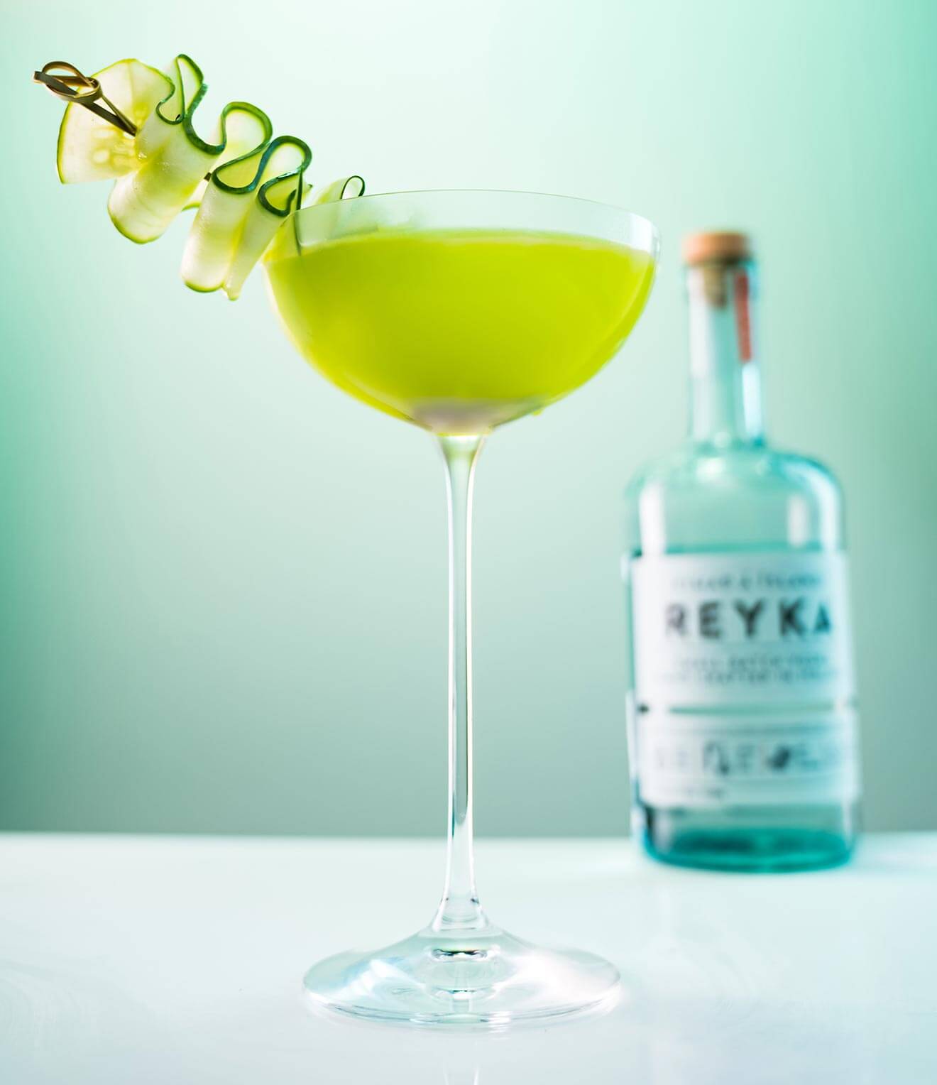 The Sophisticated Shamrock, cocktail with cucumber garnish and bottle