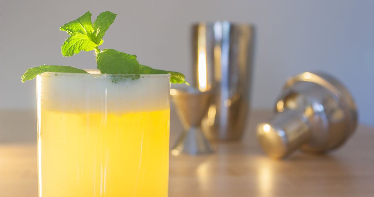 A fresh drink with mint garnish with stainless steel shaker, jigger and top., featured image