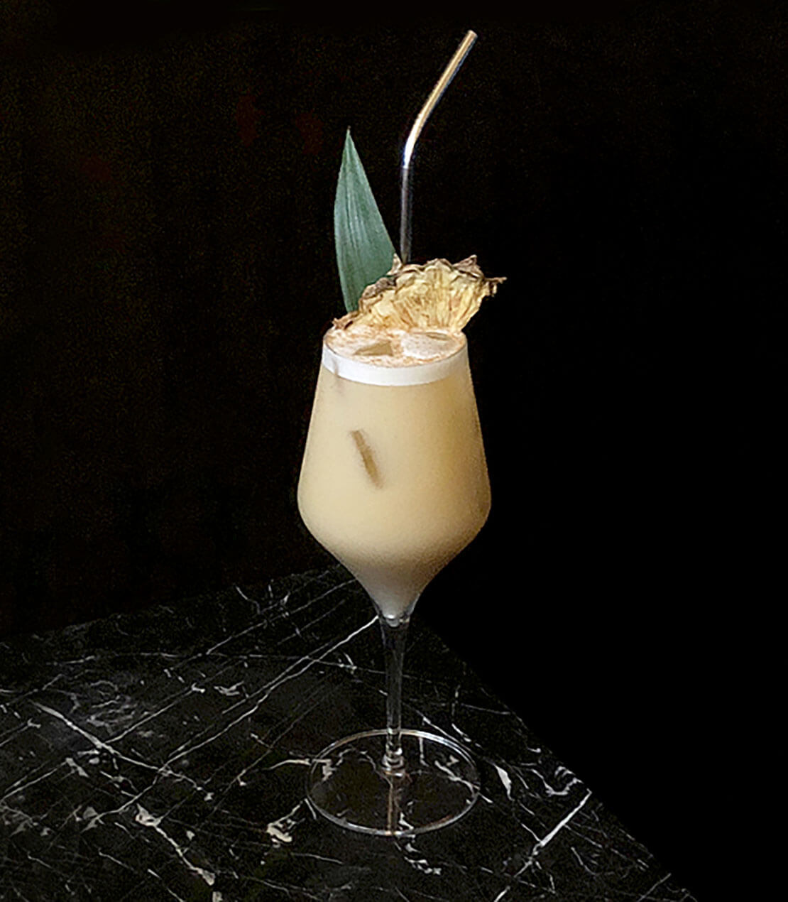 the trinidad cooler, cocktail with garnish, dark background