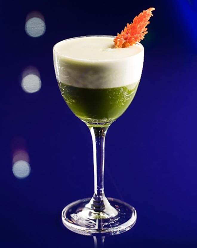 Turkish Rose Tea cocktail with garnish, blue background