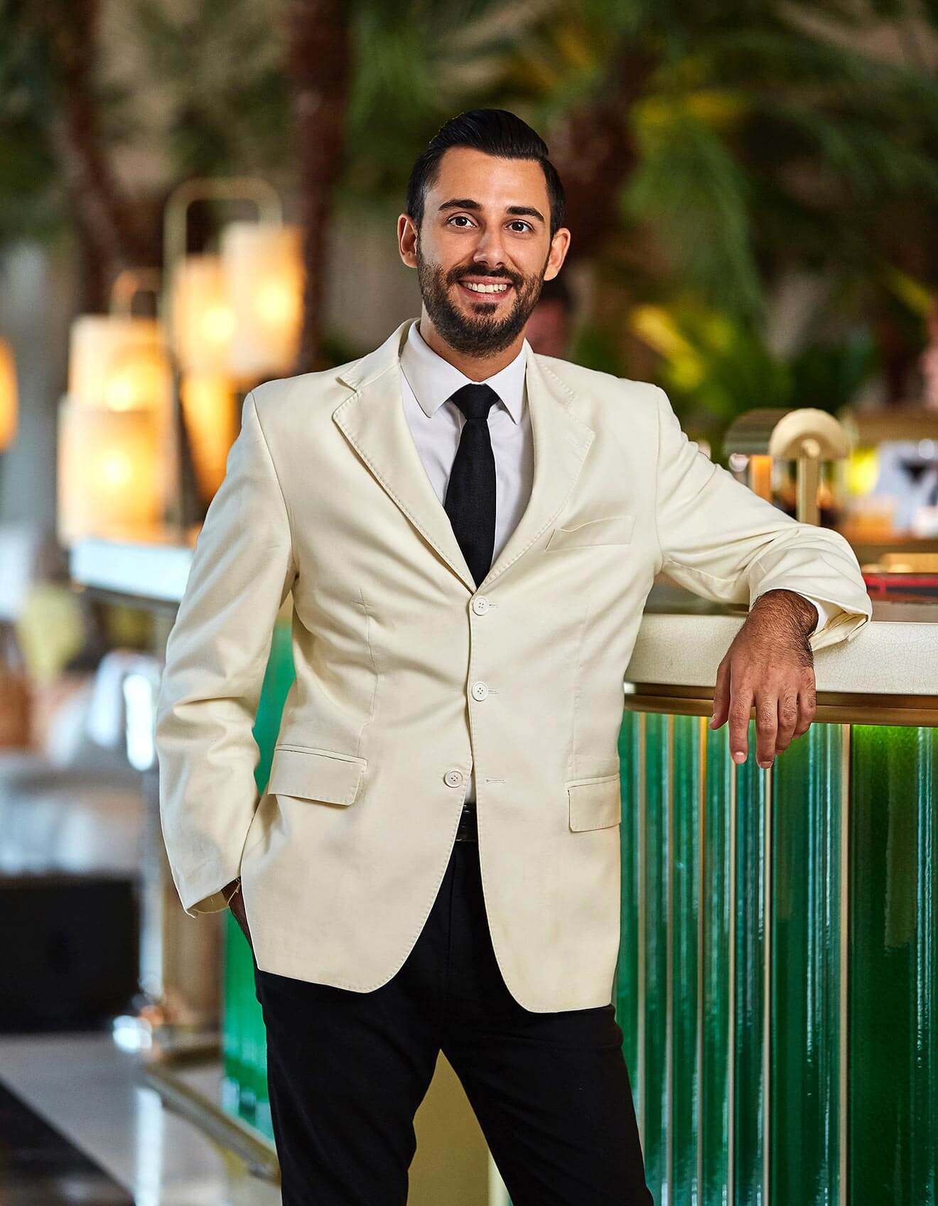 Valentino Longo - Chilled 100 Member, Miami, portrait, cream colored suit, green fence
