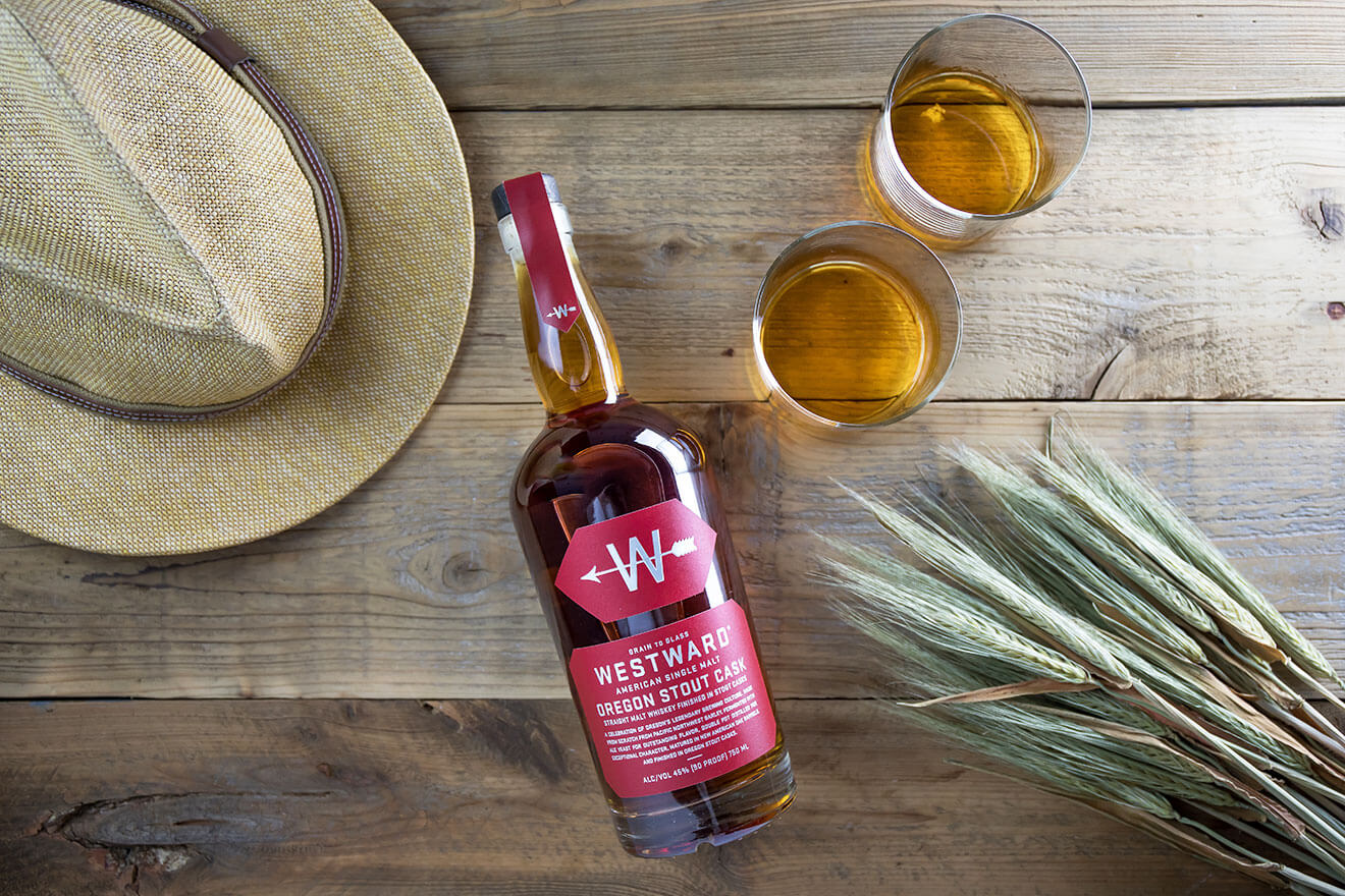Westward Stout Cask, bottle, glasses, hat on wooden table