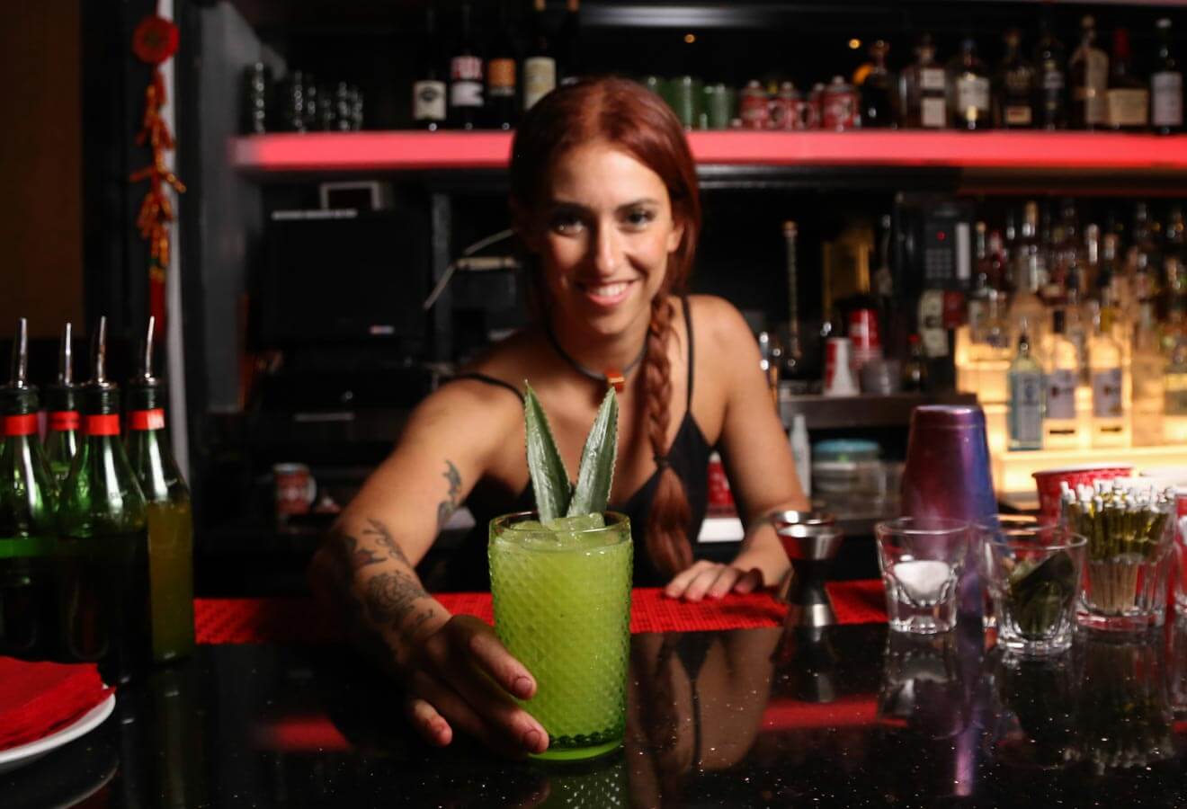 Yael Vengroff, mixologist presenting cocktail at bar