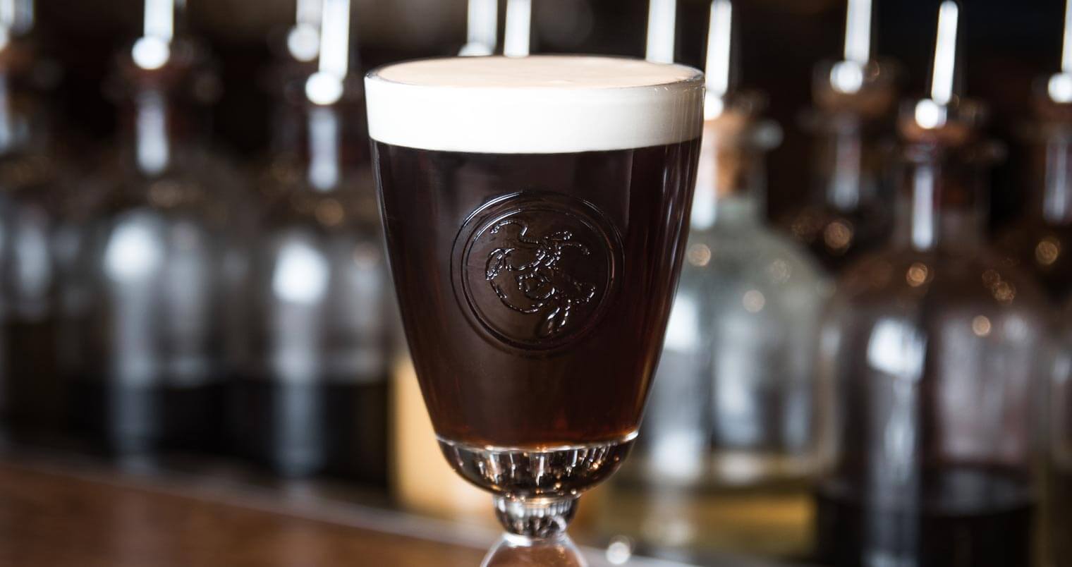 Dead Rabbit Irish Coffee, cocktail on wooden bartop, featured image
