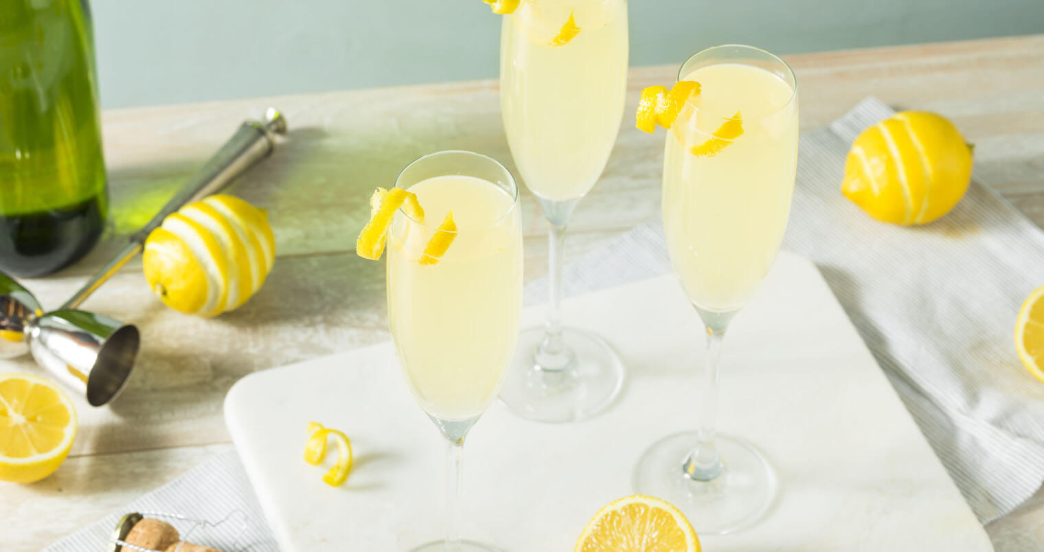 French 75 cocktails, with lemon garnish, tray and lemons, featured image