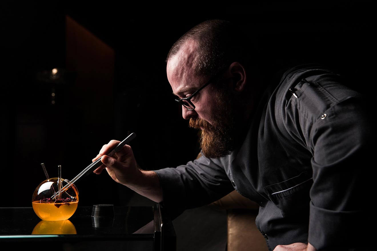 bob peters of charlotte nc, mixing a gourmet cocktail, dark background