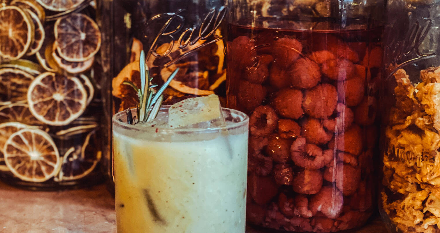 AVOrita, cocktail with mason jars of garnish, featured image