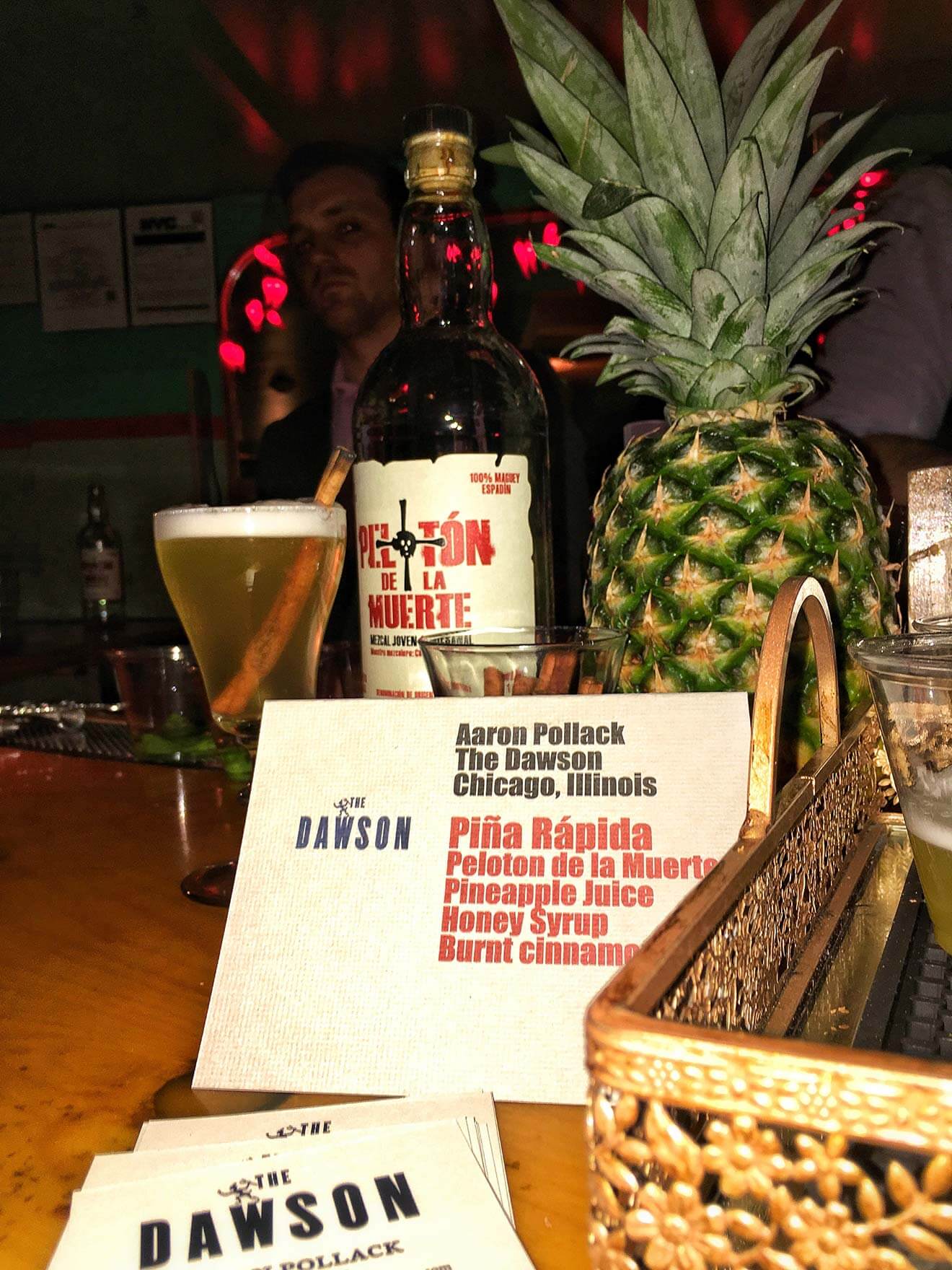 Pelóton de la Muerte, glass, menu and pineapple on bartop