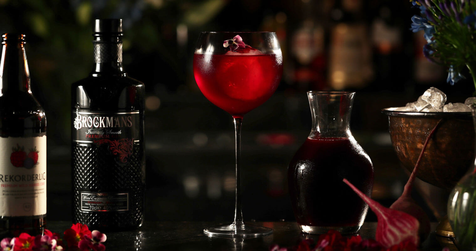 Purple Spring, cocktail with garnishes, dark background, featured image
